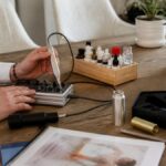 frequency-therapy-training-with-certificate-the-path-2026-1790119812-1 - Herbert Eder - Frequency Researcher A manicurist using an electric nail drill on a wooden table, with bottles of nail polish and manicure tools nearby
