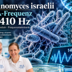 Actinomyces israelii - Herbert Eder - Frequenzforscher Two researchers in white polo shirts smile in a lab, with a DNA/bacteria backdrop and a display showing 14.410 Hz in the foreground.