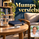Mumps verstehen - Herbert Eder - Frequenzforscher Thermometer, Wasserglas und geschlossenes Notizbuch vor einem Sessel; Anna und Herbert rechts unten.
